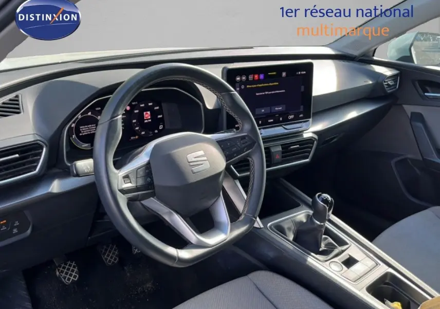 Vue intérieure côté conducteur du tableau de bord et volant du SEAT LEON blanc neige 2025 avec boîte manuelle.