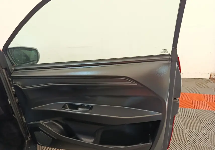 Vue rapprochée de la porte côté conducteur ouverte d’une AIXAM AMBITION 0.5 CITY PACK rouge 2024.