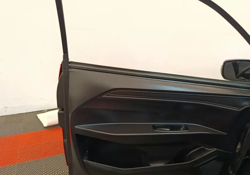 Vue intérieure de la porte côté conducteur de l'AIXAM AMBITION 0.5 CITY PACK rouge 2024 avec poignée et haut-parleur intégrés.