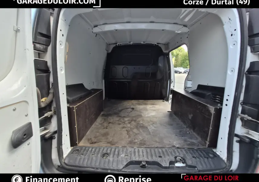 Vue intérieure arrière du Renault Kangoo blanc montrant l'espace de chargement vide avec cloison noire pleine.