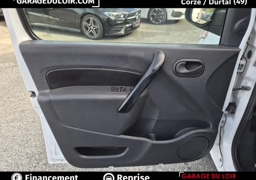 Vue intérieure côté gauche de la porte avant noire du Renault Kangoo Extra R-Link dCi 90 blanche, avec poignée et commande de vitre.