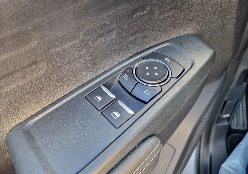 Gros plan sur les commandes de réglage des rétroviseurs et des vitres côté conducteur du Ford Ranger Super Cabine gris Iconic 2026.