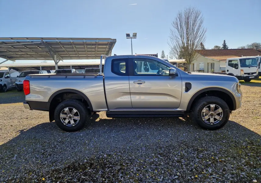 Vue de profil côté gauche d’un Ford Ranger Super Cabine gris Iconic 2026 avec roues alliage et benne ouverte.