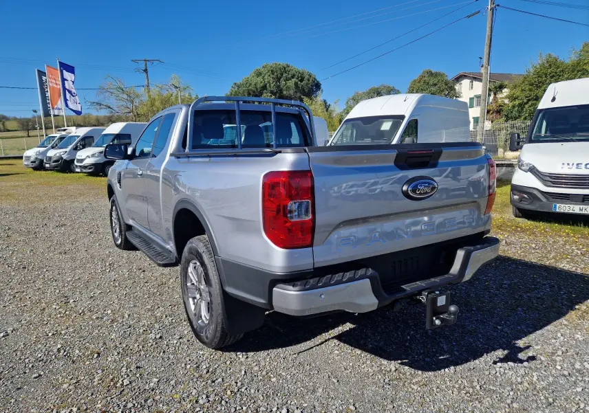 Ford Ranger Super Cabine gris iconic vu en 3/4 arrière droit, avec attelage et barres de protection sur la benne.