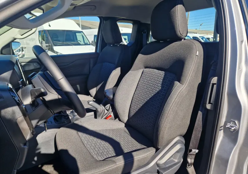 Vue intérieure côté conducteur du Ford Ranger Super Cabine gris Iconic 2026, sièges tissu avec motifs hexagonaux et volant multifonction.