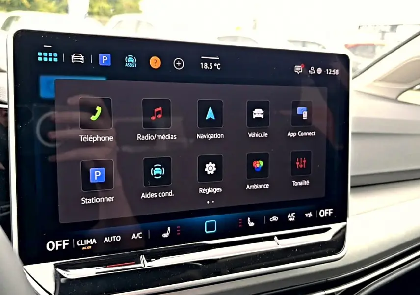 Écran tactile central de la Volkswagen Golf 2026 affichant le menu principal, vue de face côté conducteur.