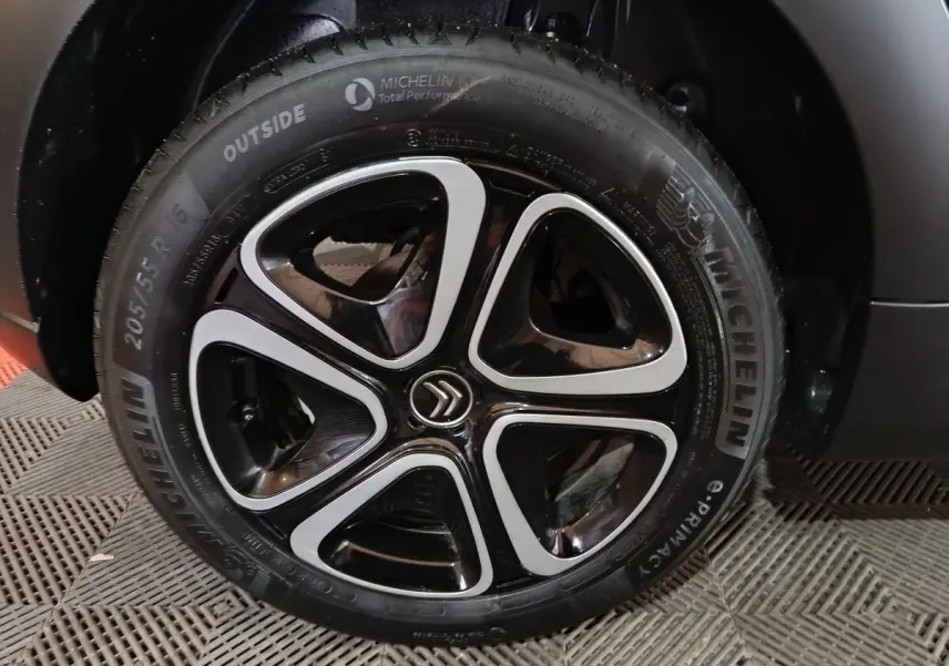 Gros plan sur la roue avant droite gris clair de la Citroën C3 2024 avec jante alliage noire et argentée au logo Citroën.