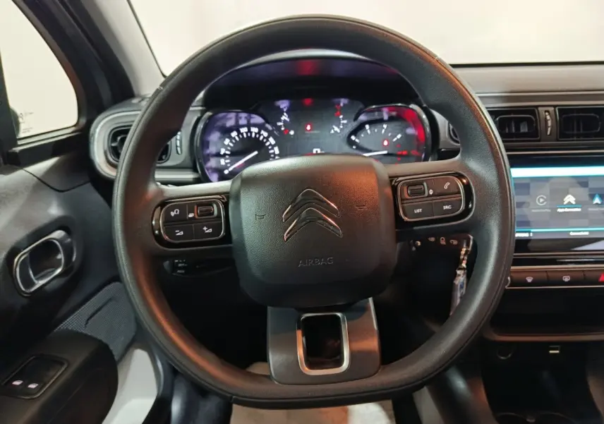 Vue intérieure centrée sur le volant noir multifonctions et le tableau de bord digital de la Citroën C3 2024.