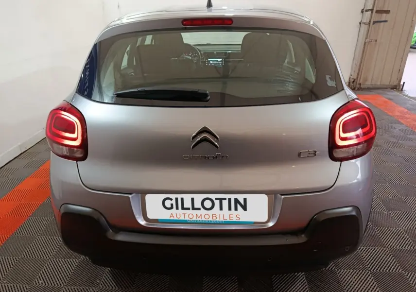 Vue arrière d'une Citroën C3 gris clair 2024 avec feux LED allumés et pare-chocs noir contrastant.