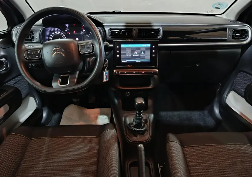 Vue intérieure avant de la Citroën C3 2024 gris clair, avec tableau de bord central tactile et volant multifonctions.
