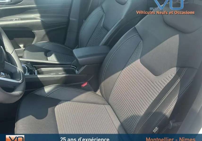 Gros plan sur les sièges avant noirs du Jeep Compass e-Hybrid 2024, mettant en valeur les surpiqûres et l'accoudoir central.