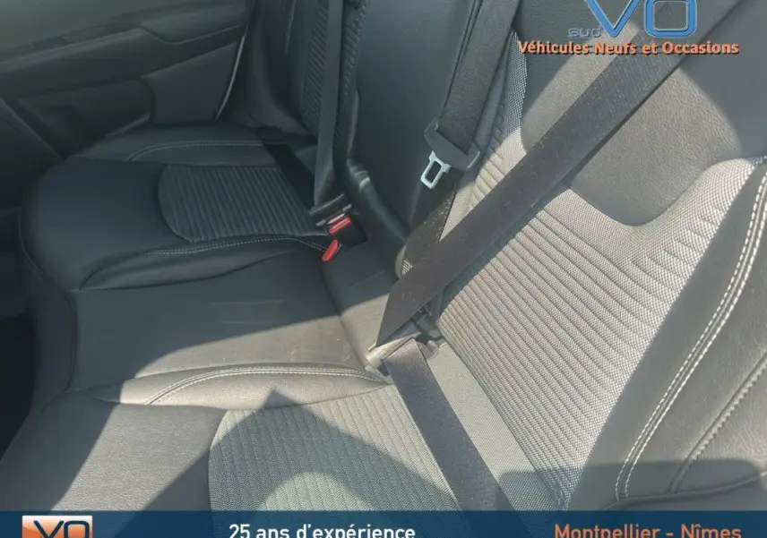 Gros plan sur la banquette arrière en cuir noir du Jeep Compass 2024, avec ceinture de sécurité attachée.