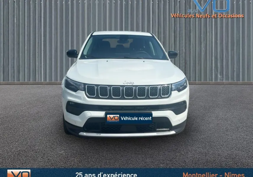Vue frontale d'un Jeep Compass blanc 2024 avec calandre caractéristique et pare-chocs noir contrastant.