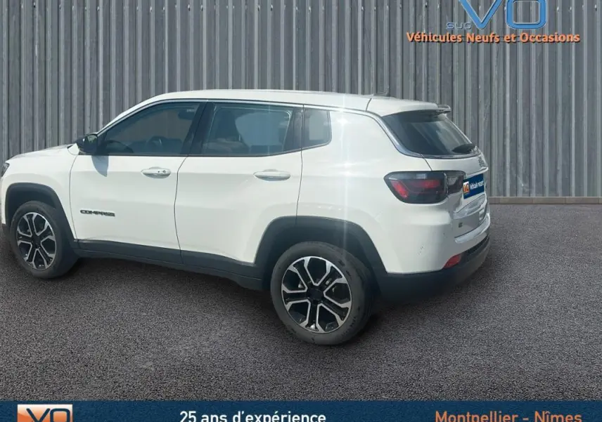 Vue latérale côté gauche d'un Jeep Compass blanc 2024 avec jantes 17 pouces et roue de secours visible à l'arrière.