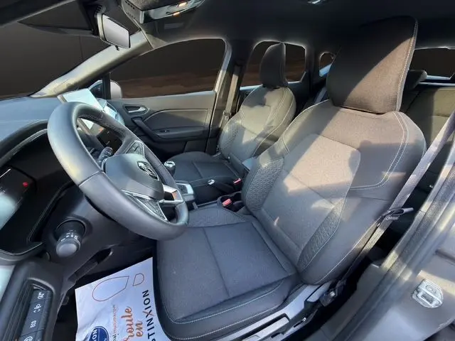Intérieur du Renault Captur 2024 côté conducteur, sièges tissu noir avec volant et levier de vitesse visibles