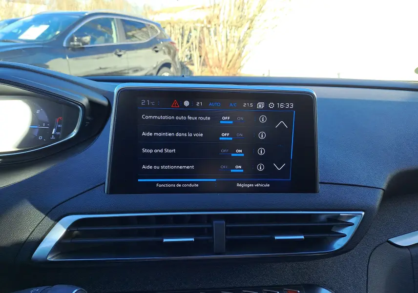 Écran tactile central du tableau de bord du Peugeot 5008 gris, affichant les réglages d'aides à la conduite.