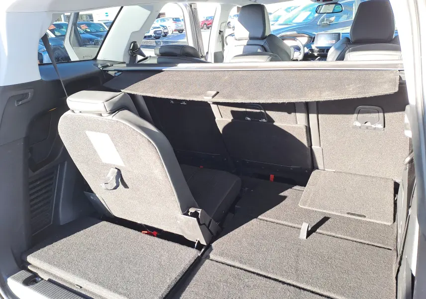 Vue arrière intérieure du Peugeot 5008 gris, montrant la banquette arrière partiellement rabattue et l'espace de chargement.