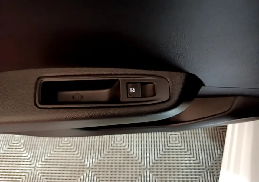 Détail de la commande de verrouillage sur la portière intérieure côté conducteur d’une Renault Clio blanche 2023.