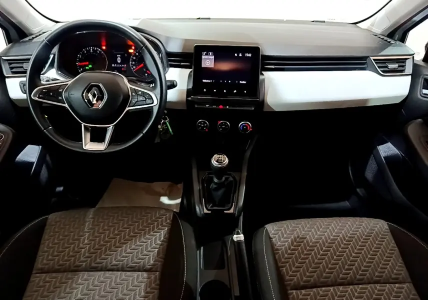 Vue intérieure avant de la Renault Clio Business 2023, tableau de bord noir et blanc avec écran tactile central et volant multifonctions.