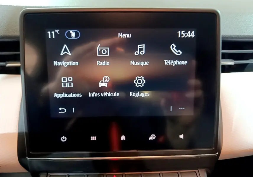 Écran tactile central de la Renault Clio Business blanc, affichant le menu principal avec options multimédia et navigation.