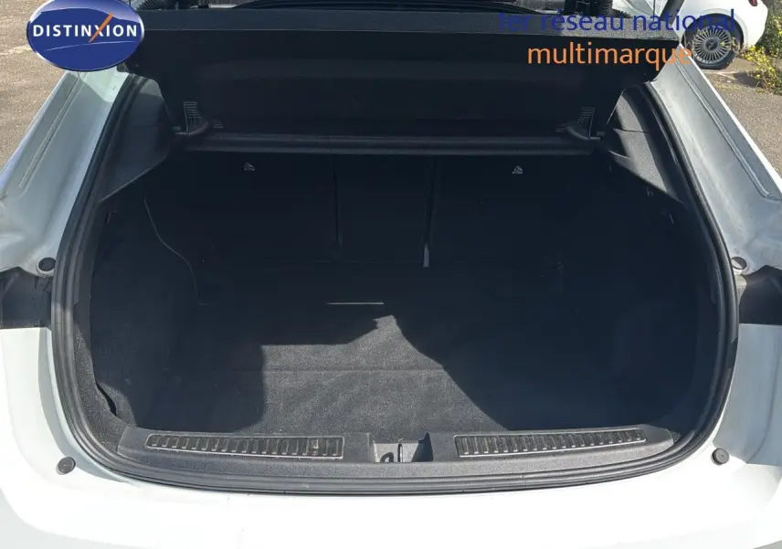 Coffre ouvert vu de l'arrière d'une Renault Rafale blanc satin avec intérieur noir, sans chargement visible.