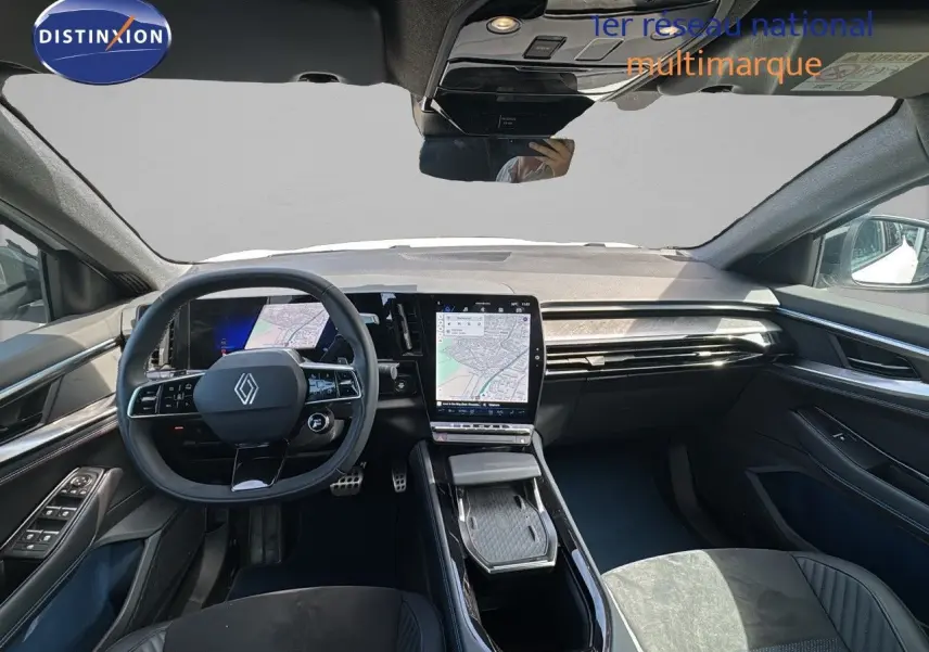 Vue intérieure avant de la Renault Rafale 2024, tableau de bord moderne avec écran tactile central et volant multifonction noir.