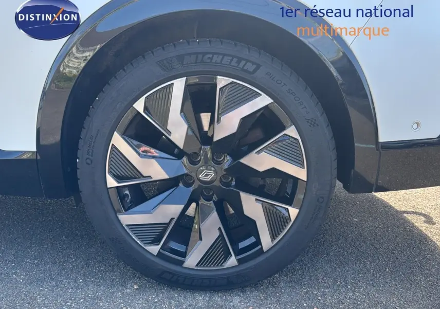 Gros plan sur la roue avant droite du Renault Rafale blanc satin avec jante noire et argentée au design moderne.