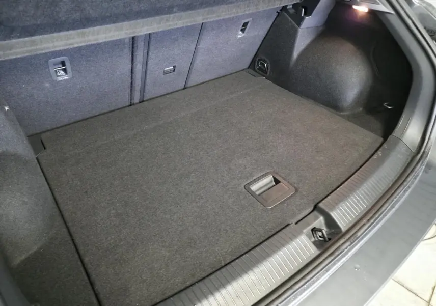 Coffre spacieux du Volkswagen T-Roc gris 2025 vu de dessus, avec plancher plat et éclairage intérieur.