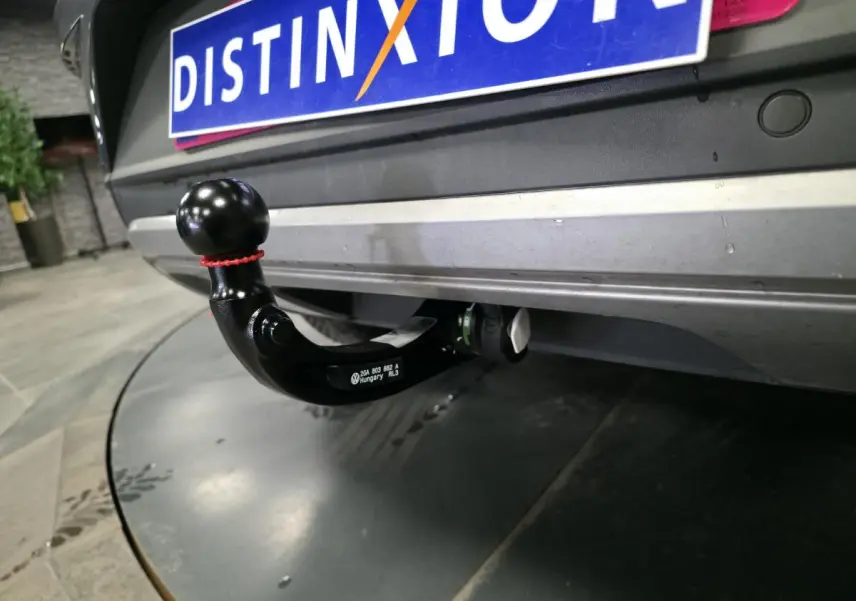 Gros plan sur l'attelage démontable noir sous le pare-chocs arrière gris métallisé du Volkswagen T-Roc 2025.