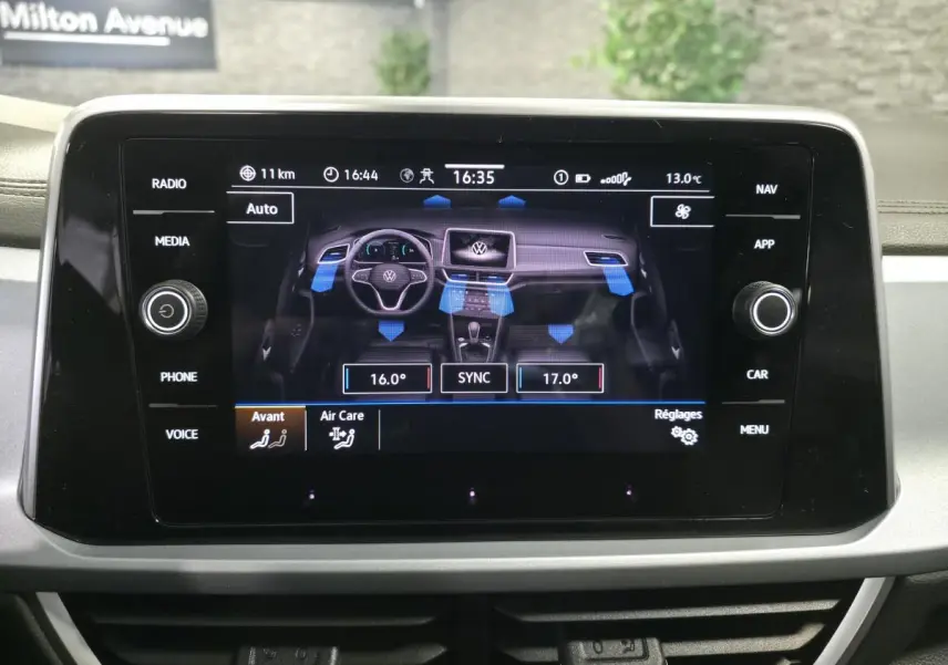 Écran tactile central du Volkswagen T-Roc 2025 affichant les réglages de climatisation bi-zone et la ventilation.