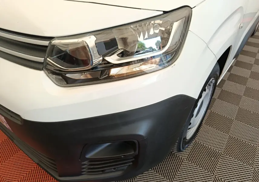 Gros plan sur l'avant droit blanc du Citroën Berlingo 2020, mettant en valeur le phare et le pare-chocs noir.