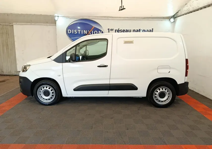 Vue latérale droite d’un utilitaire Citroën Berlingo blanc avec porte latérale pleine et jantes acier.