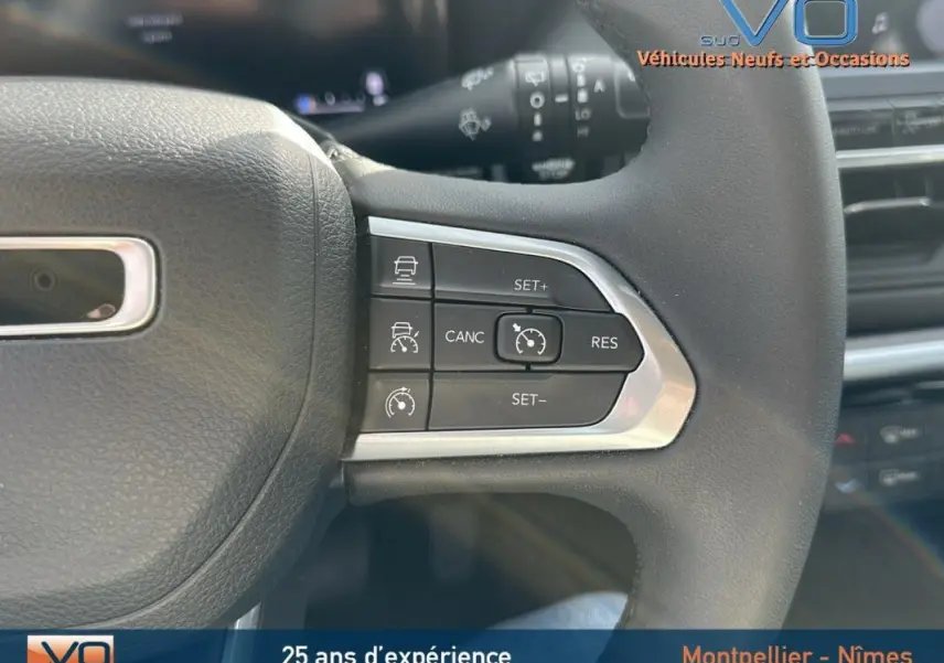 Gros plan sur les commandes du régulateur de vitesse au volant d’un Jeep Compass gris 2024 e-Hybrid Altitude