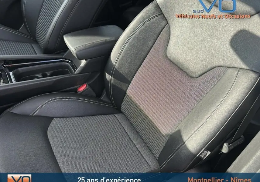 Gros plan sur le siège conducteur en cuir noir et tissu du Jeep Compass 2024 avec accoudoir central visible.