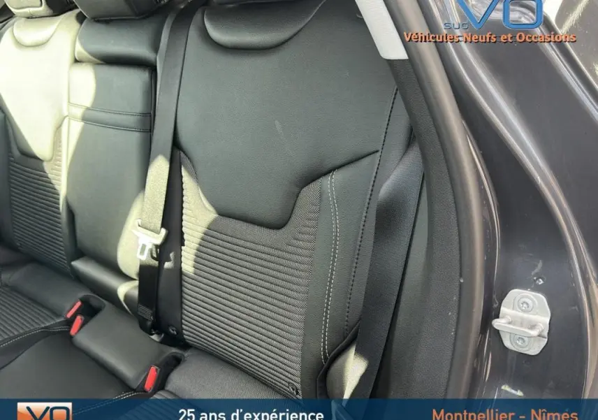 Gros plan sur la banquette arrière en cuir noir du Jeep Compass gris 2024, avec ceinture de sécurité visible côté droit.