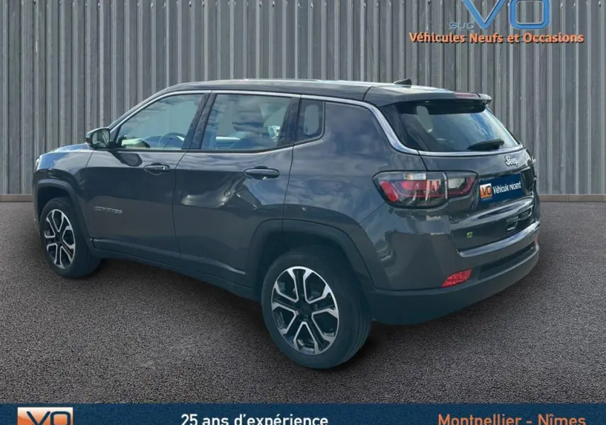 Jeep Compass gris en vue 3/4 arrière droit, avec jantes alliage 18 pouces et feux arrière LED visibles.