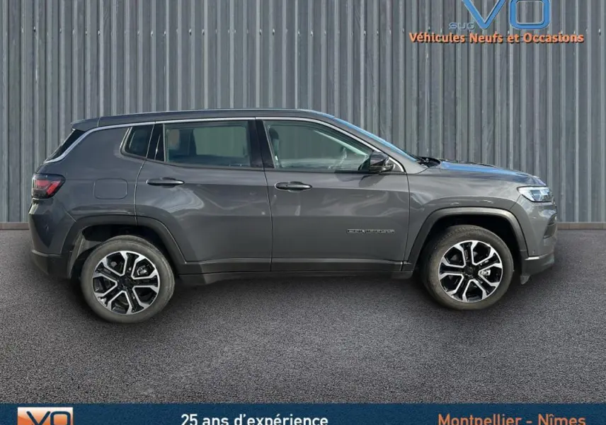 Profil côté gauche d'un Jeep Compass gris 2024 avec jantes alliage 18 pouces sur fond industriel.