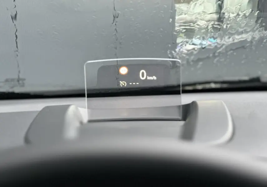 Affichage tête haute du tableau de bord de la Citroën C3 Aircross 2024, vitesse à 0 km/h sous pluie.