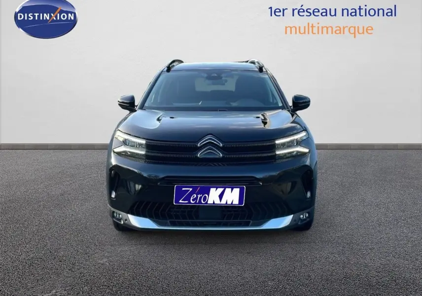 Vue frontale d'un Citroën C5 Aircross noir perla metal avec calandre distinctive et phares LED allumés.