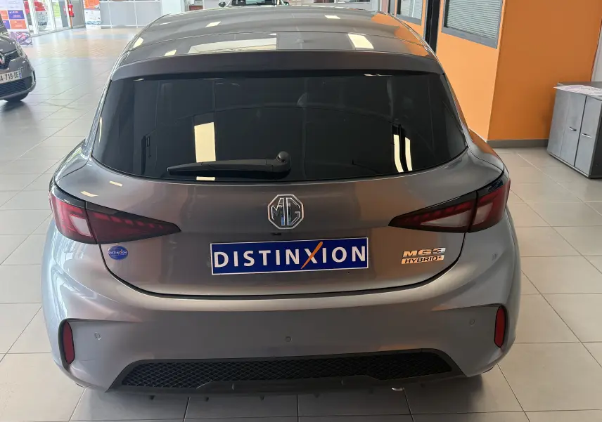 Vue arrière d'une MG3 1.5 L Hybrid+ gris hampstead avec feux arrière étirés et logo MG visible en concession.