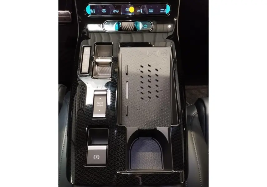 Vue plongeante sur la console centrale noire brillante du Citroën C5 Aircross avec commandes tactiles et rangement à induction.