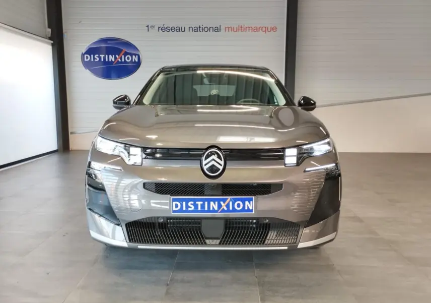 Vue frontale d'une Citroën C5 Aircross gris platine avec calandre noir brillant et feux LED distinctifs.