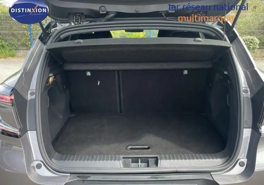Coffre ouvert vu de l'arrière d'un Renault Captur 2025 gris Cassiopée métal avec toit noir, montrant l'espace de chargement vide.