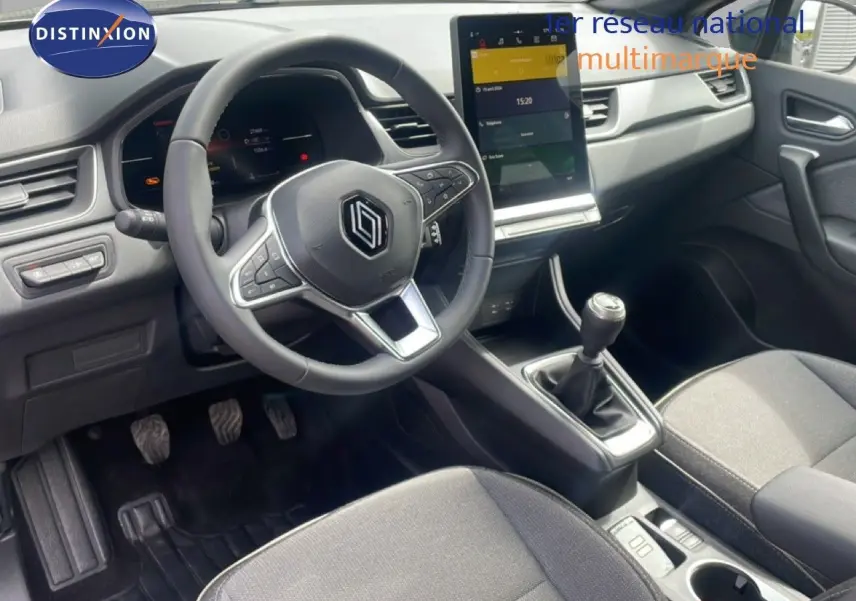 Intérieur avant du Renault Captur 2025, vue côté conducteur, volant multifonction et écran tactile central.