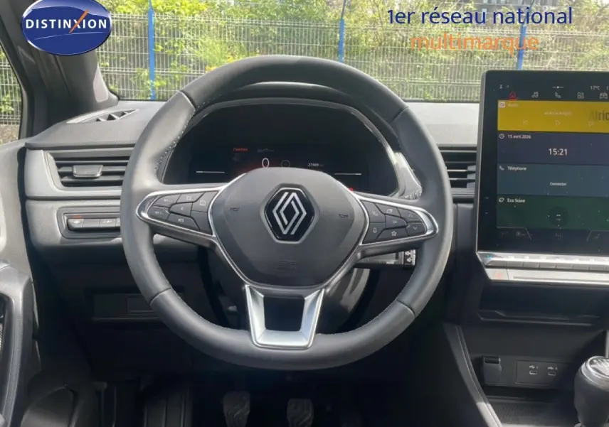 Vue centrée sur le volant noir du Renault Captur 2025, avec tableau de bord numérique et écran tactile à droite.