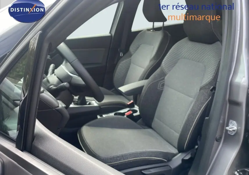 Vue intérieure côté conducteur du Renault Captur gris Cassiopée métal, montrant les sièges en tissu gris et la console centrale.