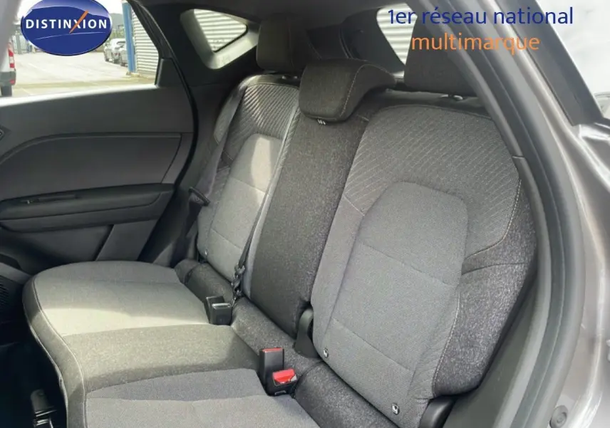 Vue intérieure côté droit montrant la banquette arrière grise du Renault Captur 2025 avec tissu bi-ton et appuie-têtes intégrés.