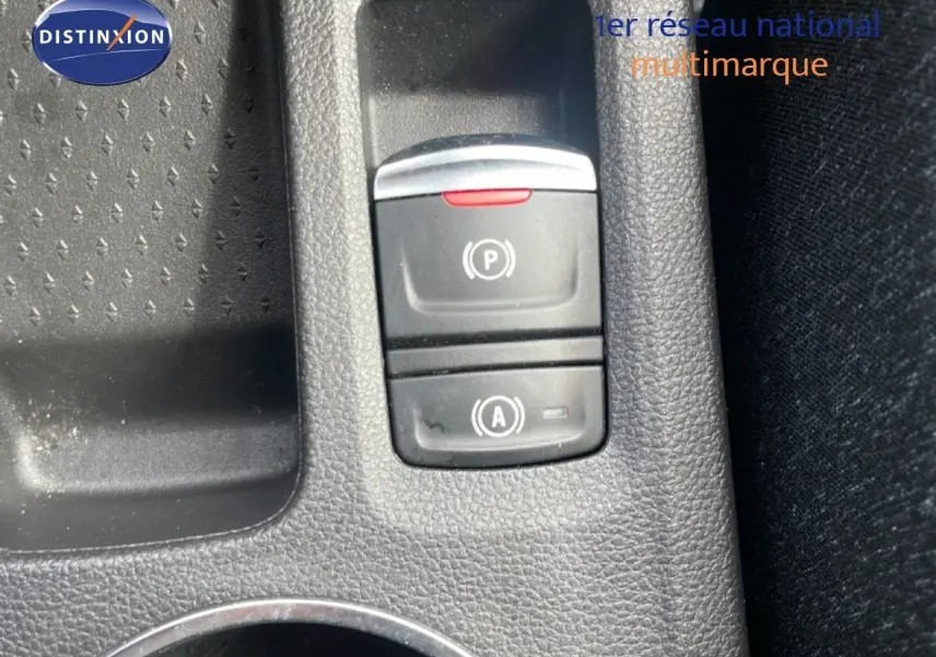Gros plan sur les commandes de frein à main électronique et d'arrêt automatique du moteur du Renault Captur gris Cassiopée métal.