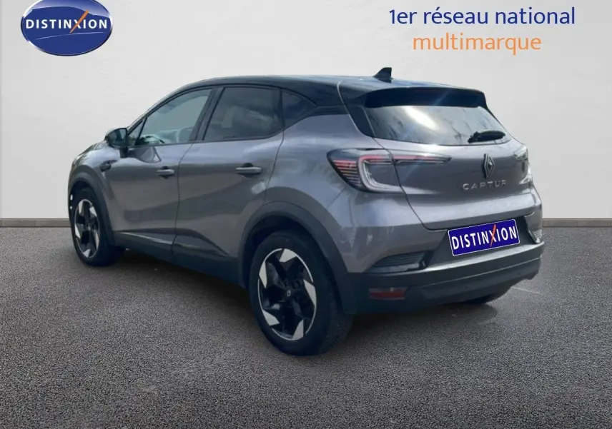 Vue 3/4 arrière droite d'un Renault Captur gris Cassiopée métal avec toit noir, jantes bi-ton et feux LED distinctifs.