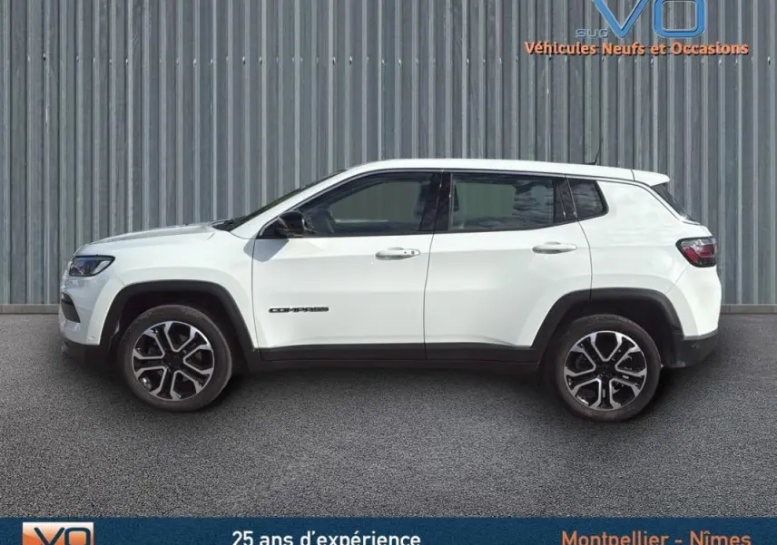 Profil latéral droit du Jeep Compass blanc 2024 avec jantes alliage 18 pouces et logo visible sur la porte